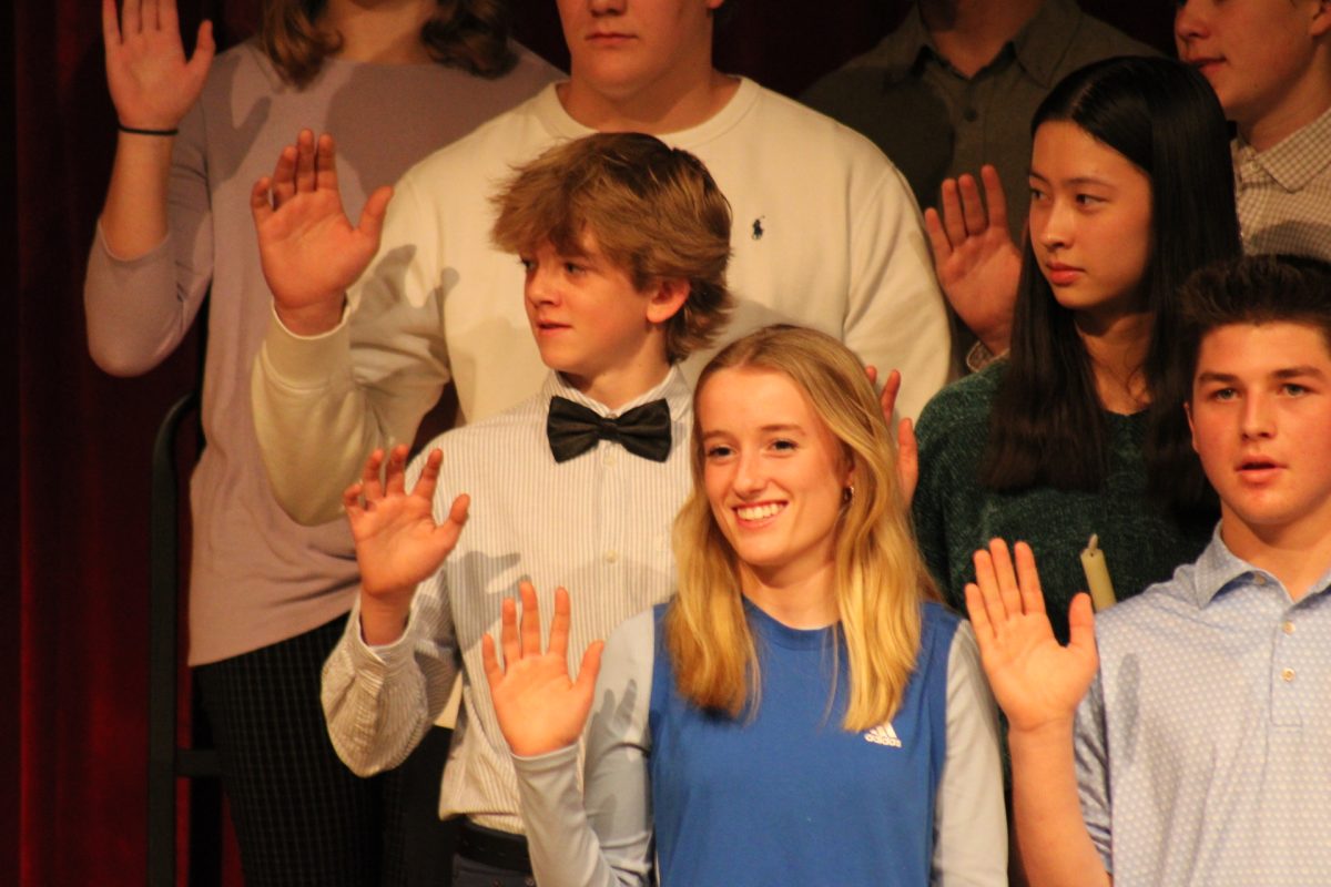 Junior Saylor Swanson  and other inductees takes an oath, at the original NHS induction for the 2023-2024 school year.